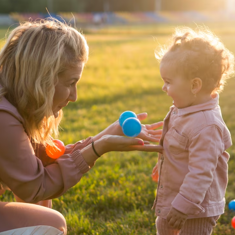 A Pair Of Mother And Daughter Are Playing With A Small Ball In The Sun