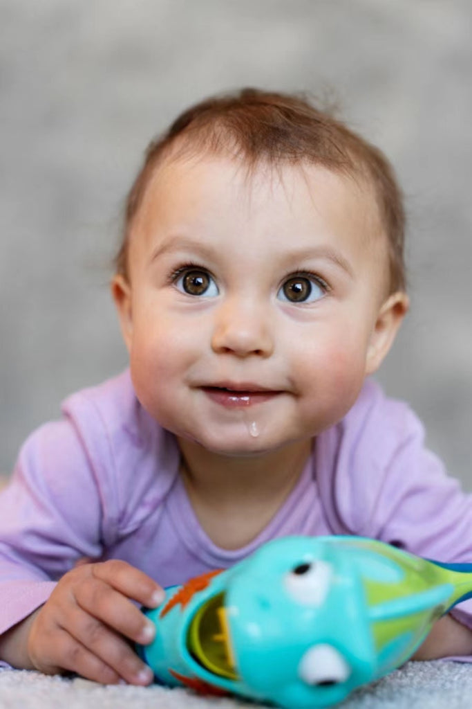 Adorable baby laying playing floor with toy