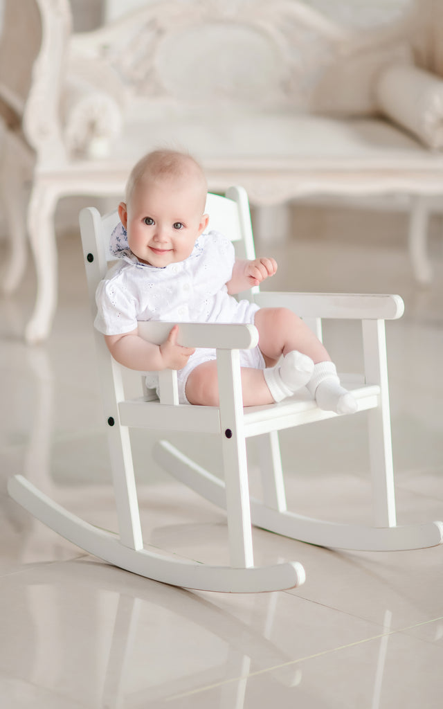Charming newborn boy sits chair