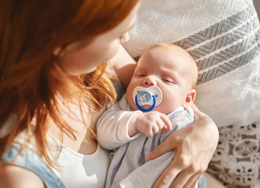 Mom holding a baby with a pacifier