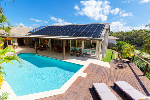 solar pool heater panels on roof above outdoor inground swimming pool