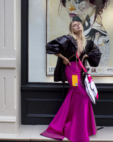 Girl wearing long evening fuchsia dress with street style designer bear bag 