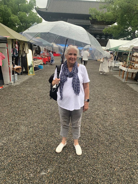 Jo with umbrella standing in front of To Ji temple and market