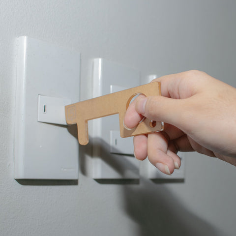 acrylic no-touch tool being used to turn-on a switch