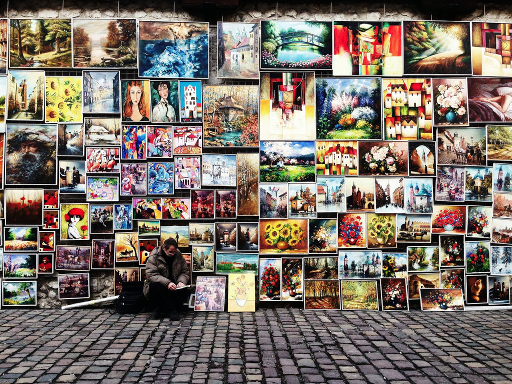 Beata Ratuszniak photograph of an artist on a street trying to sell, with all of his artwork lined up around him