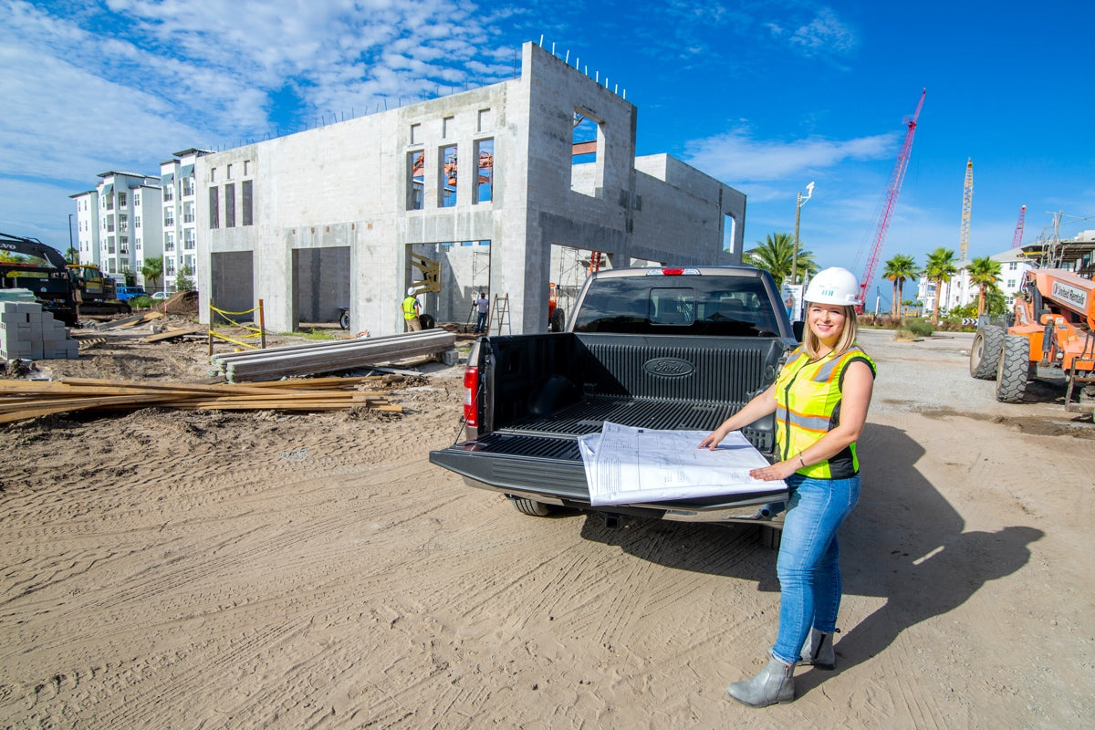 Britney Mroczkowski looking at building plans on a job site with BTI Partners