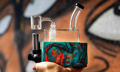 Stache RIO held over grafitti background blue orange square dab rig