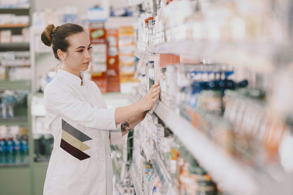 pharmacist organizing medicine rack