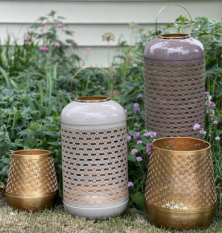 Four punched metal lanterns of various sizes and shapes.