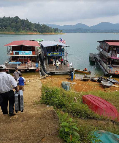 Beberapa pelawat sedang berjalan ke arah rumah bot yang di jadikan tempat penginapan dan kenderaan untuk bergerak ke sekitar Tasik Kenyir.