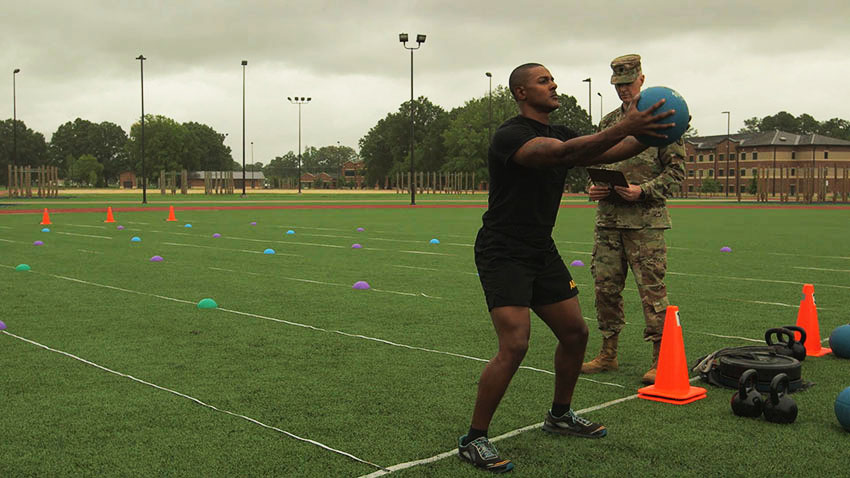 Soldier back-throwing a medicine ball for ACFT