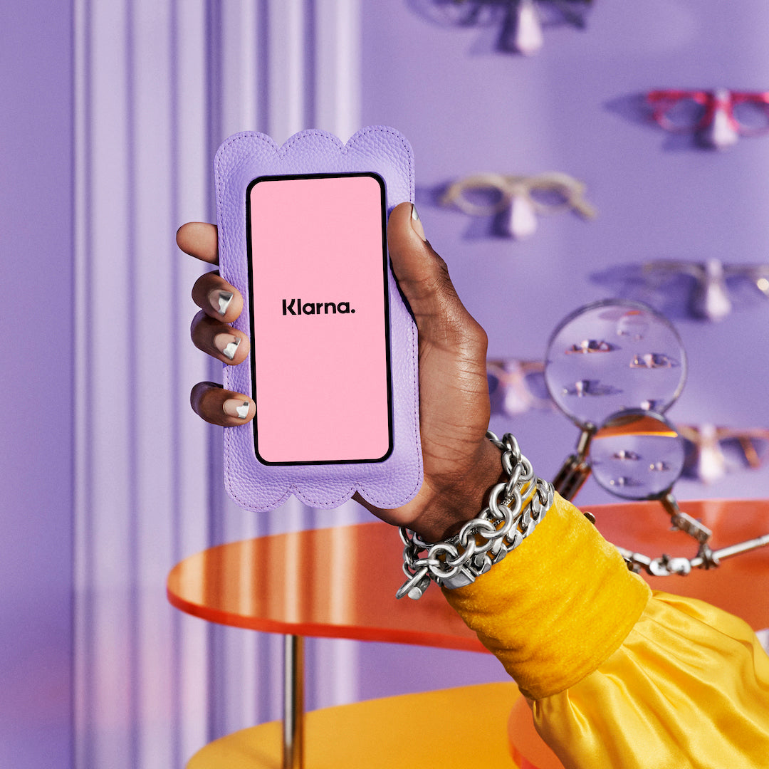 Cell phone being held with Klarna logo