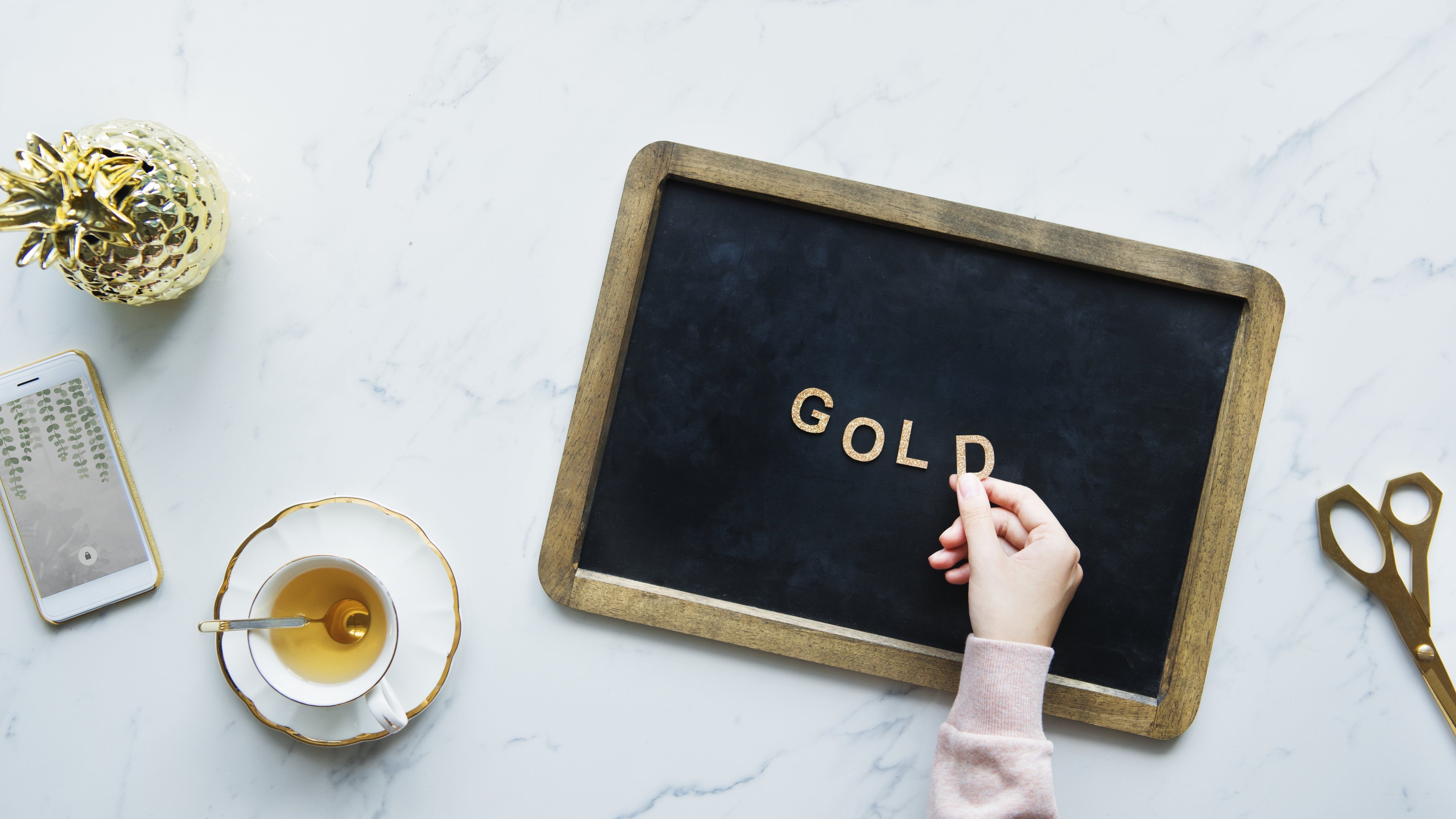 Woman Spelling Gold During Coffee Break