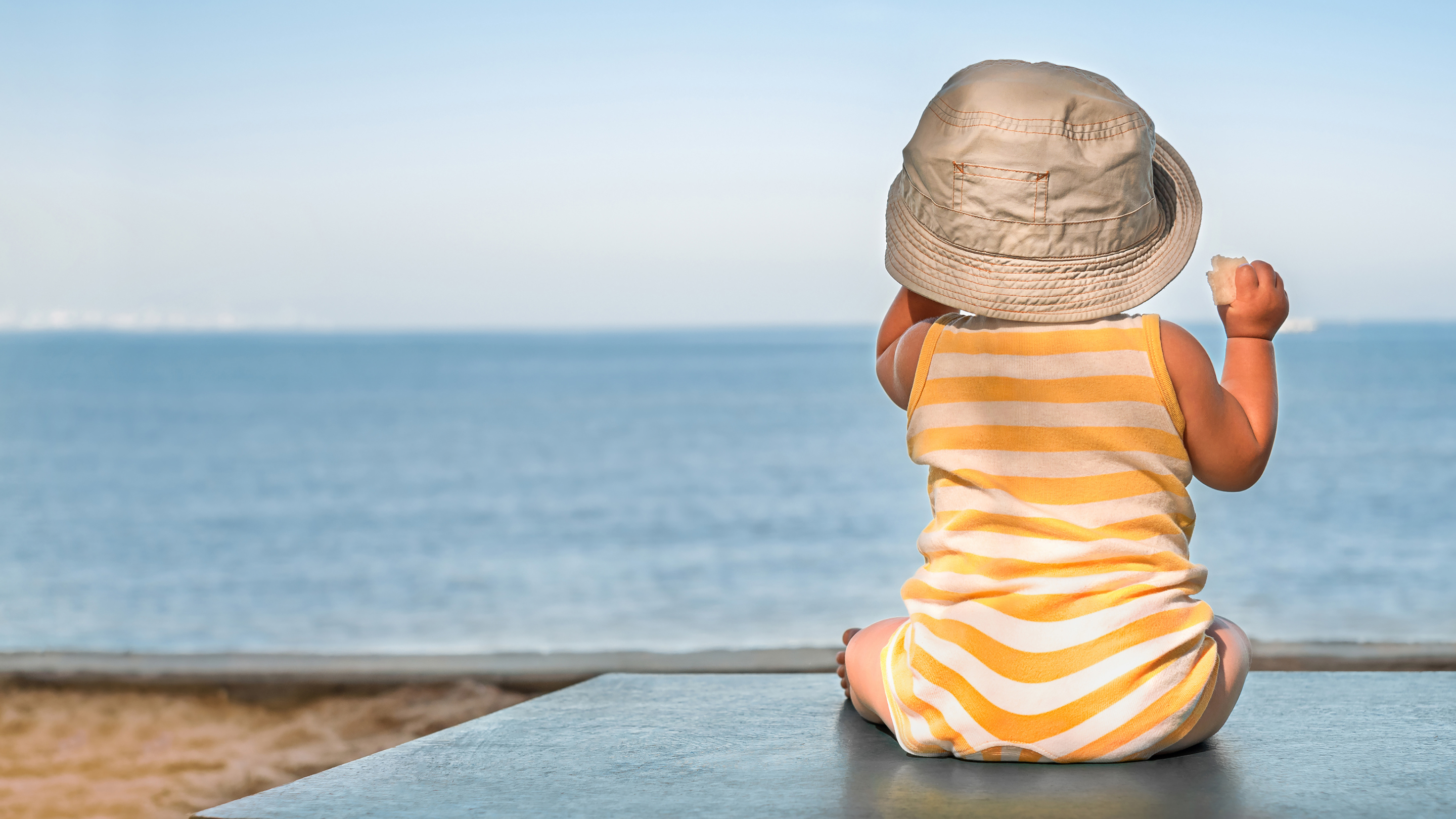 Bébé au soleil avec un chapeau jacadi et une barboteuse jacadi