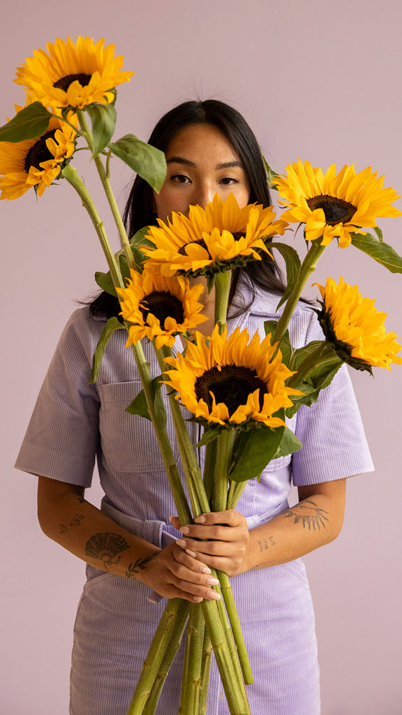 Frau mit Sonnenblumenstrauß