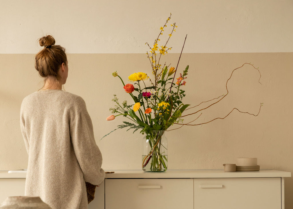 Original Bloomon Bouquet auf Schrank mit Frau daneben next