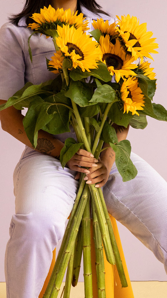 Frau mit Sonnenblumenstrauß