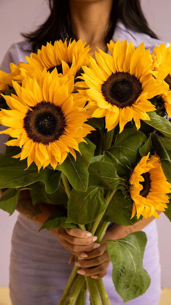 Frau mit Sonnenblumenstrauß