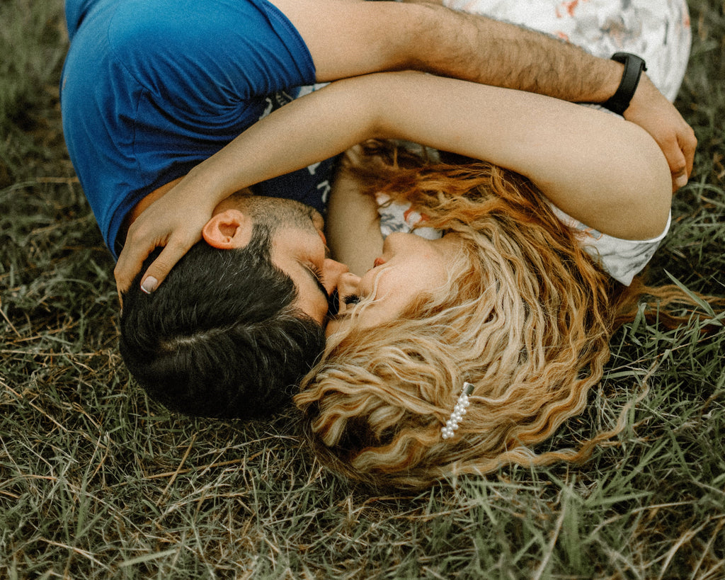 a couple holding each other laying on the ground
