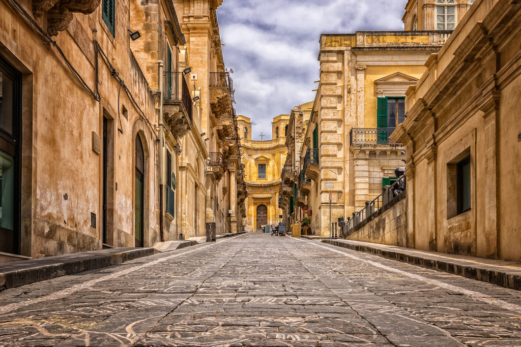 a photo of old Italian buildings and a cobblestone road