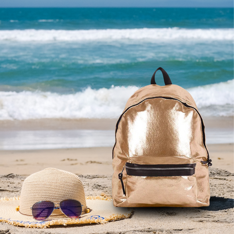 Gold Napoli Laptop Backpack on the sand at beach with sun hat and sunglasses