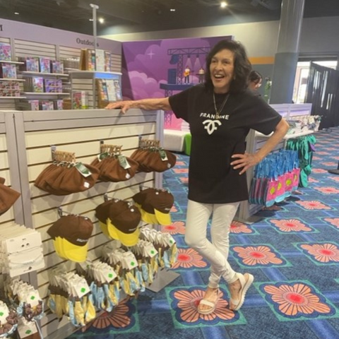 Francine Farkas Sears Poses with Product Display at the 2023 Orlando Phenom by Girl Scouts Convention