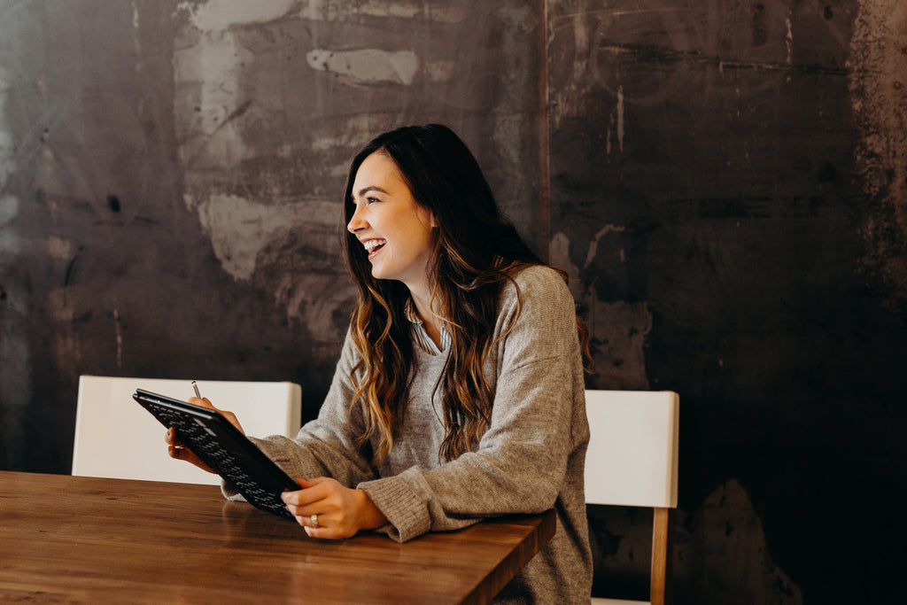 A happy lady holding a tablet in an office board room