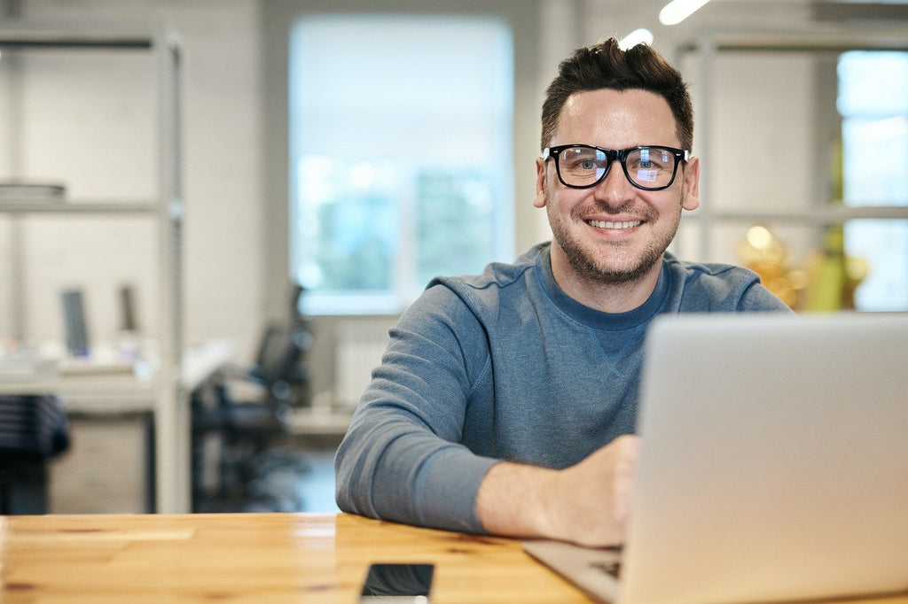 A man sits behind laptop