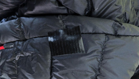 Black duct tape used to seal a hole in a down jacket