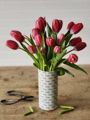 A bouquet of red tulips in a cylinder vase
