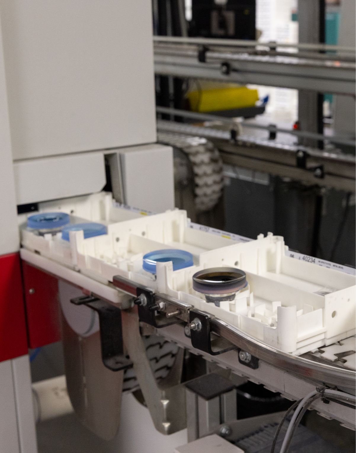 Factory conveyor belt with small containers in a manufacturing facility.