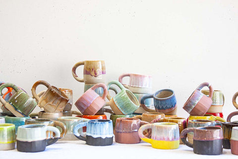collection of handmade ceramic mugs glazed in bright colours