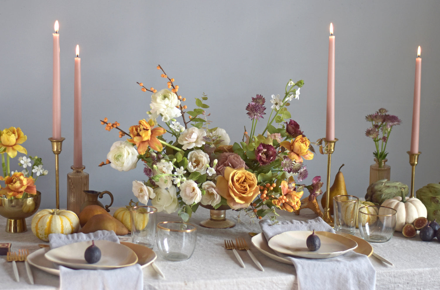 tablesetting tips with pink candles in brass candlesticks, white pumpkins, ceramic plates, and organic floral arrangements