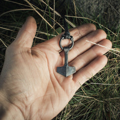 Model holding the Mjolnir pendant necklace with ring.