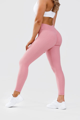 Girl posing wearing pink adapt scrunch bum leggings and white classic crop top, behind