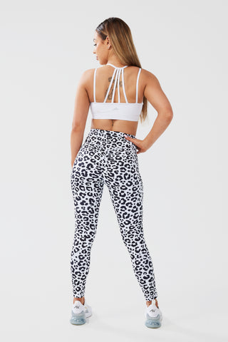 Girl posing hand on hip looking to side wearing luxe scrunch bum leggings in leopard print and white classic crop top