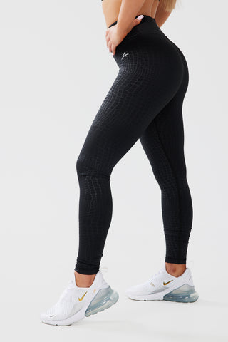 Side shot of girl posing hands on hips wearing luxe snake print leggings