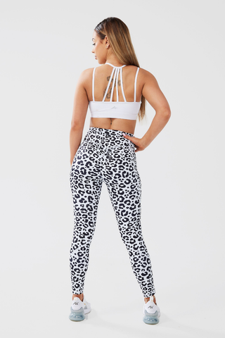 Girl posing hand on hip looking over shoulder wearing luxe scrunch bum leggings in leopard print and white classic crop top