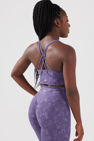 Close up shot of girl posing hands on hips wearing legacy scrunch bum leggings and sports bra in purple, back