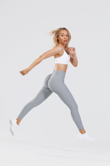 Girl leaping in air wearing grey adapt scrunch bum leggings and classic crop top