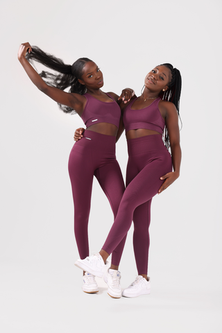 Two girls posing together wearing invictus seamless sports bra and leggings in plum purple