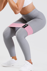 Close up of girl wearing pink medium resistance band around thighs and adapt seamless scrunch bum leggings in grey