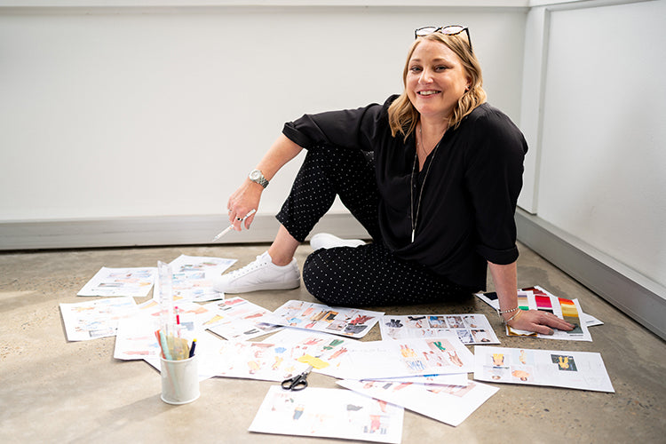 Ali sitting on the ground surrounded by design inspiration