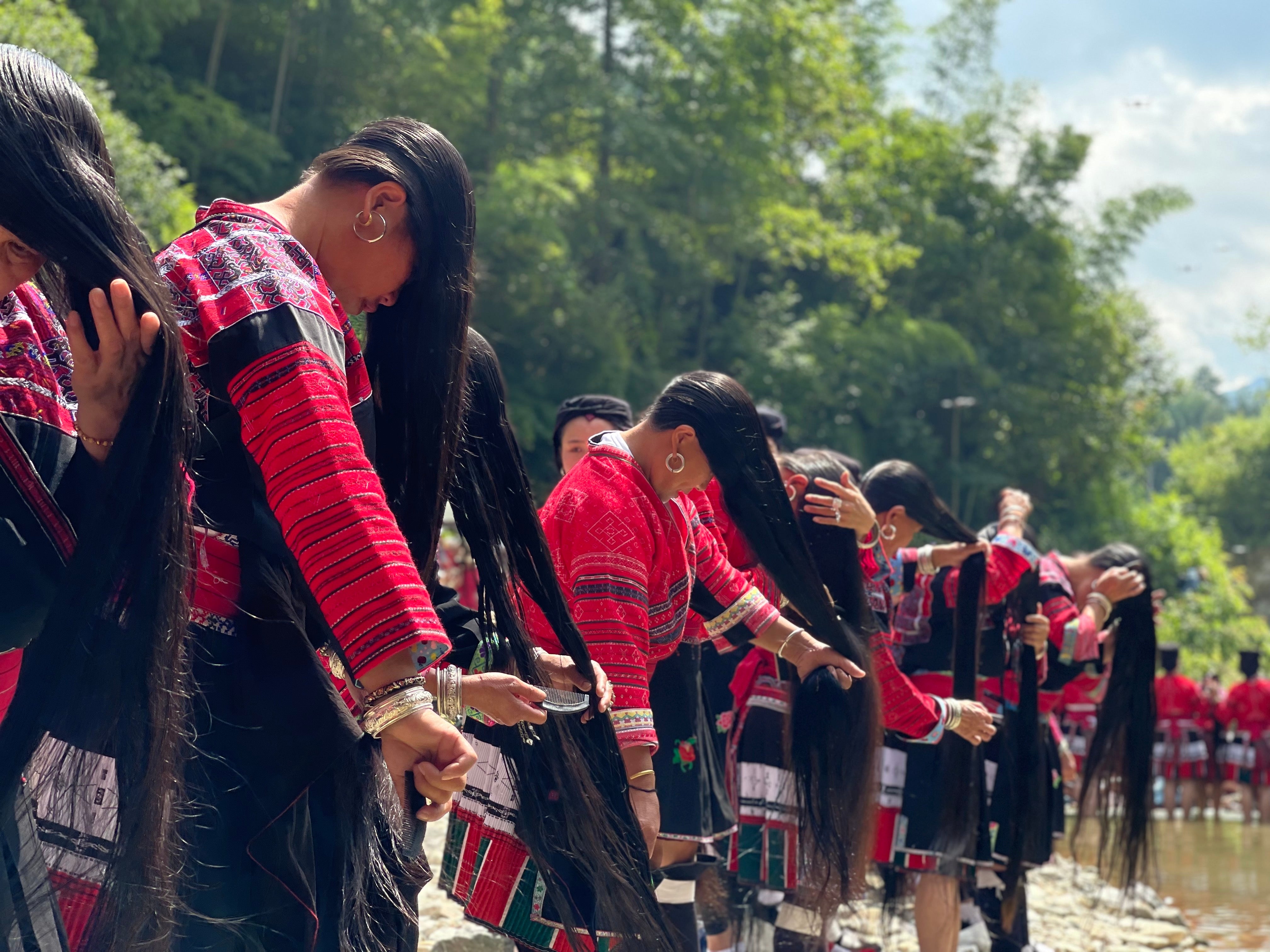 Red Yao women washing their hair at the  annual 'Clothes Hanging' festival.