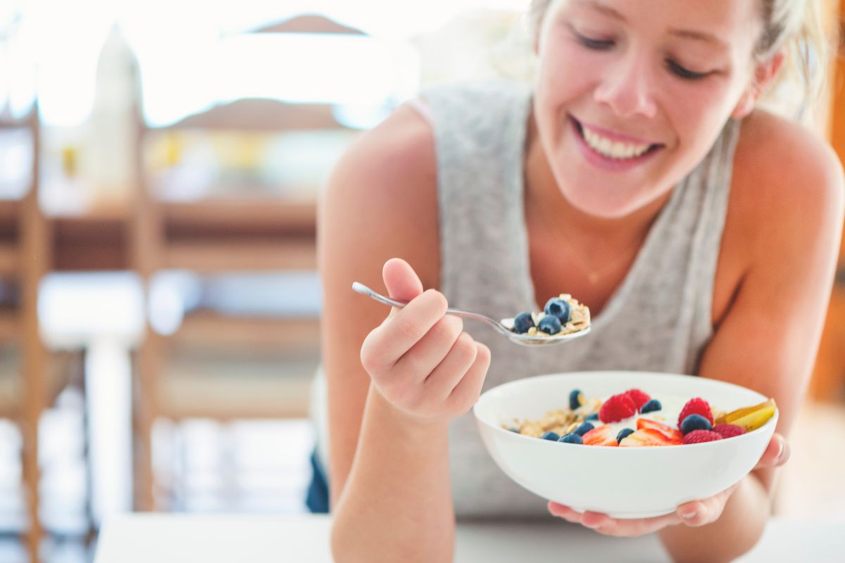 Happy woman eating healthy breakfast