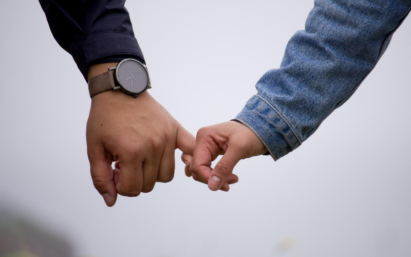 Couple holding by pinky finger