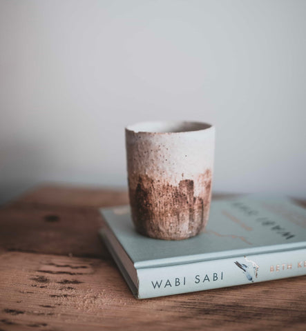 tea cup on top of wabisabi book on wooden table