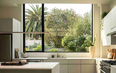 organized minimalist kitchen with large picture window showing nature