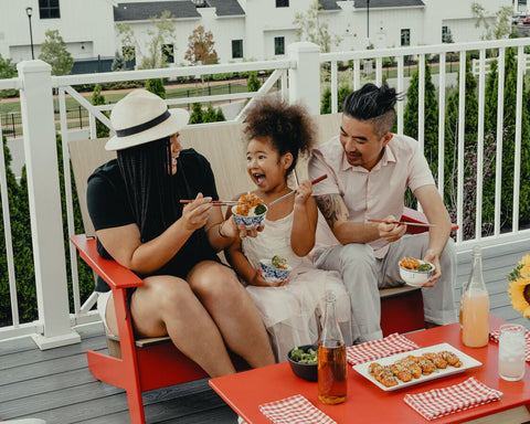 smiling family enjoying meal in their backyard patio on deck