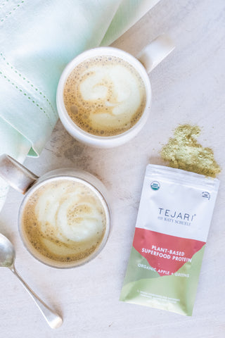 two cups of clean green dairy-free latte with Tejari Organic Apples + Greens Blend pouch